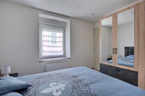 1 dormitorio con 1 cama grande y espejo en Appartement 2 pièces pleins de charmes (Géorgie) en Audincourt