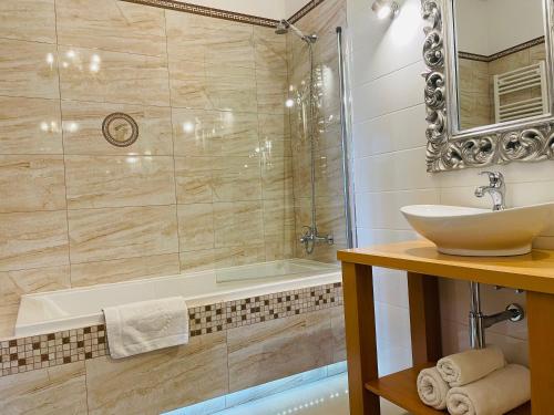 a bathroom with a sink and a bath tub at Apartamenty Blisko Centrum in Toruń