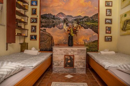 two beds in a room with a painting on the wall at Apartments RUZA in Crikvenica