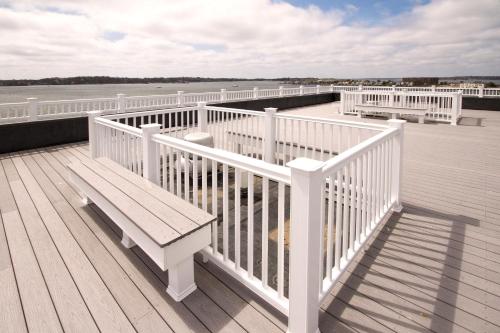 a wooden deck with a bench on a pier at Club Wyndham Inn on Long Wharf in Newport