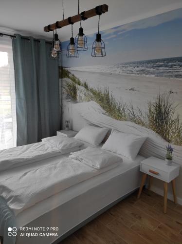 a bedroom with a bed with a beach mural at Apartament Baltic13 in Gąski