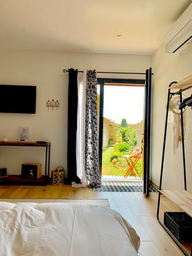 une chambre avec un lit et une porte coulissante en verre dans l'établissement Atelier des Vidaux, à Saint-Aunès