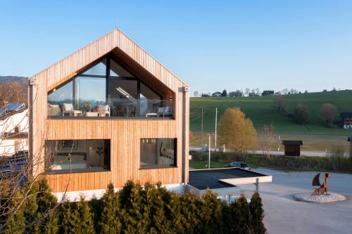 a house with large glass windows on the side of it at HIMMELBLAU - Design Apartment am Mondsee in Mondsee