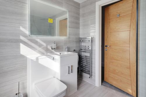y baño con lavabo blanco y espejo. en Master accommodation suite 3 sea view en Hastings