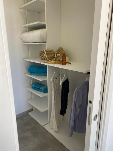 a walk in closet with white shelves and towels at Verde Oliva Residence in Ispica