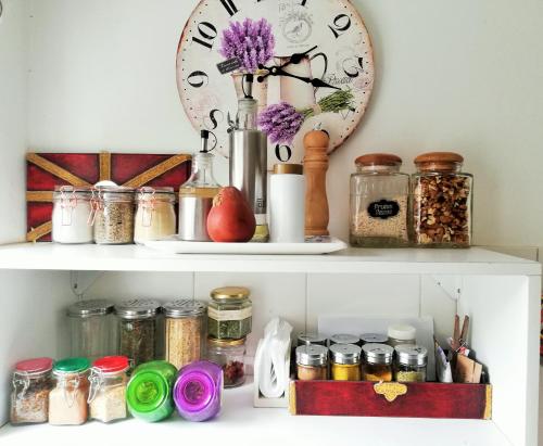 a shelf with jars and a clock on it at Alojamiento familiar in Coronel Suárez
