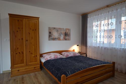 a bedroom with a bed and a wooden cabinet at Dom Gościnny Alba in Międzywodzie