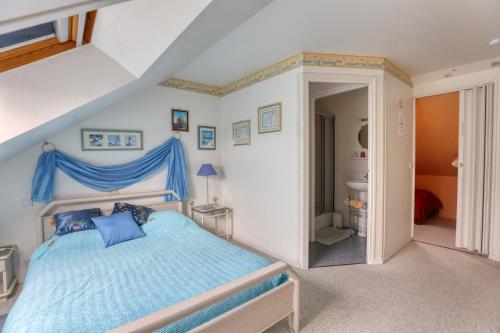 1 Schlafzimmer mit einem blauen Bett und einem Badezimmer in der Unterkunft Maison de 5 chambres avec jardin clos et wifi a Commes a 6 km de la plage in Commes