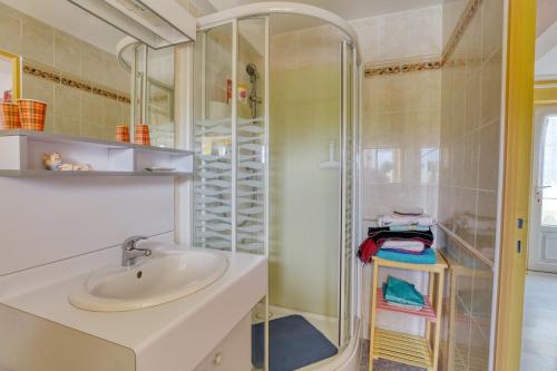 ein Bad mit einem Waschbecken und einer Dusche in der Unterkunft Maison de 5 chambres avec jardin clos et wifi a Commes a 6 km de la plage in Commes