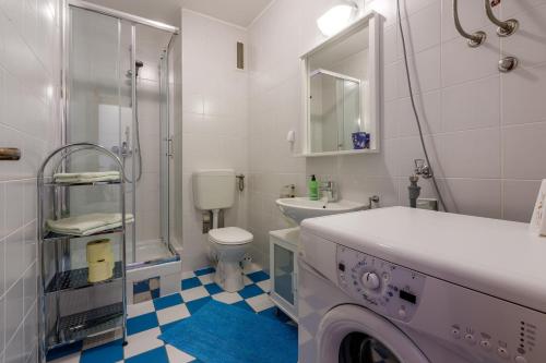 a white bathroom with a washing machine in it at Apartment Ruzica in Crikvenica