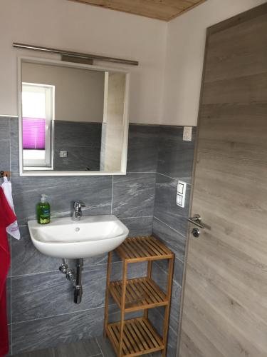 a bathroom with a sink and a mirror at Ferienwohnung Groß in Königswalde