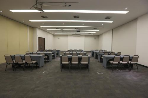 a room with rows of tables and chairs at Nobile Suítes Uberlândia in Uberlândia