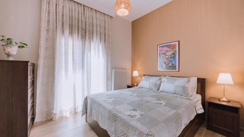 um quarto com uma cama e uma grande janela em Ιlektra's House em Kavala