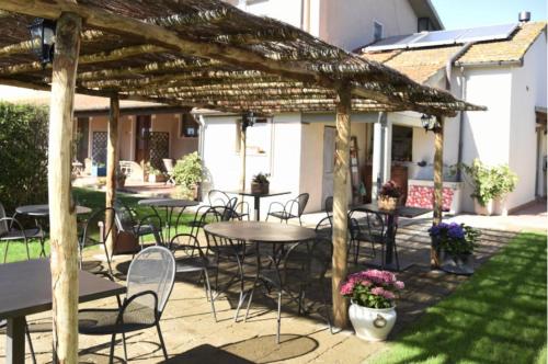 un grupo de mesas y sillas bajo una pérgola de madera en Podere Montecorno, en Alberese