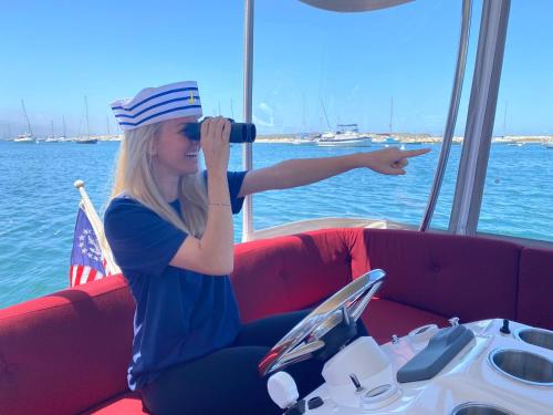 una mujer sentada en un barco mirando el agua en Anderson Inn en Morro Bay