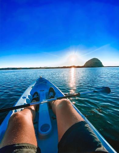 une personne montant un kayak sur une masse d'eau dans l'établissement Anderson Inn, à Morro Bay