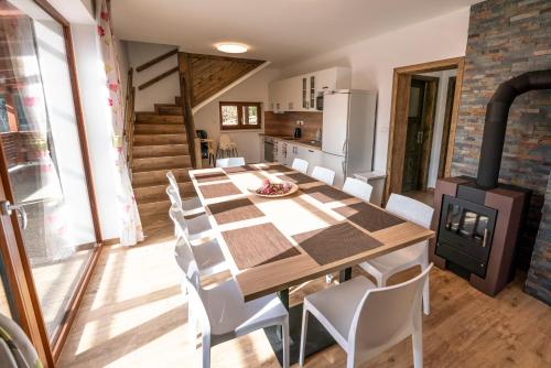 a kitchen and dining room with a long table and white chairs at Wellness Chalupa Horní Orlice in Králíky