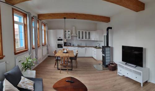 a living room with a table and a kitchen at Schulhaus Wettges in Birstein