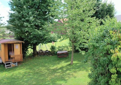 a park with a bench and a gazebo and trees at Schulhaus Wettges in Birstein