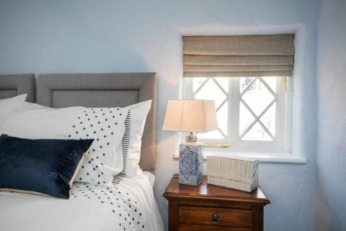 a bed with a lamp on a nightstand next to a window at Kilbroney River Cottage in Rostrevor