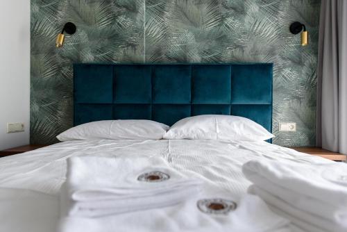 a bed with white sheets and a blue head board at Venckai Venckuose in Venckai