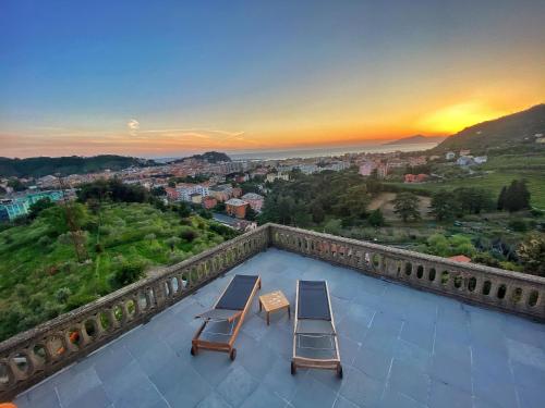 a balcony with two chairs and a view of a city at Torre Scribanti in Sestri Levante