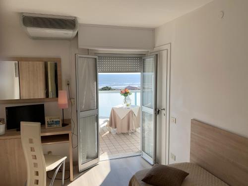 een kamer met een tafel en uitzicht op de oceaan bij Hotel Sahara in Milano Marittima