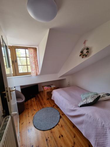 a attic bedroom with two beds and a window at Karczma Regionalna Młyn -pokoje gościne in Zwierzyniec