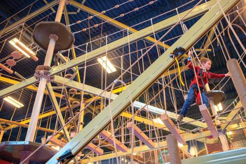 a man is climbing on a rope in a building at Club Wyndham Great Smokies Lodge in Sevierville
