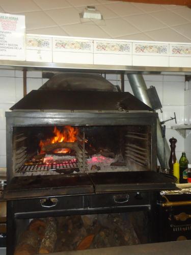 a stove in a kitchen with a fire in it at Hotel Restaurant Casa Miquel in Alcarraz