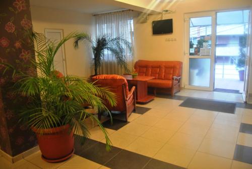 una sala d'attesa con mobili arancioni e piante di Hotel Delaf a Cluj-Napoca