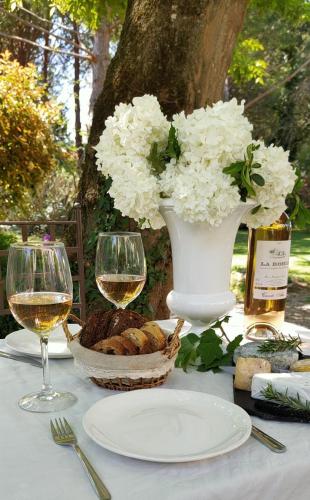 a table with glasses of wine and a vase of flowers at Le Mas d'Hermès in Plan-dʼOrgon