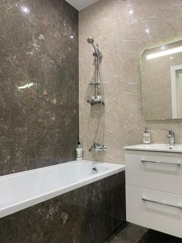 a bathroom with a tub and a sink and a mirror at 2 кімнатні ,Люкс апартаменти в ЖК Арена ,район автовокзалу in Rivne