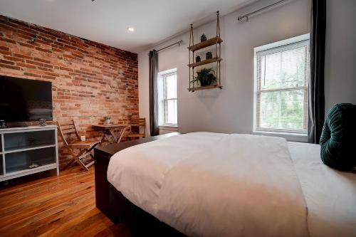 a bedroom with a large bed and a brick wall at Artsy Hidden Gem - FREE PARKING in Philadelphia