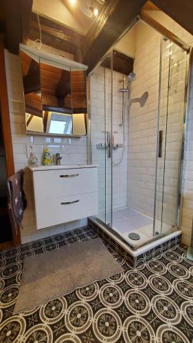 a bathroom with a shower with a glass door at Schulhaus Wettges in Birstein