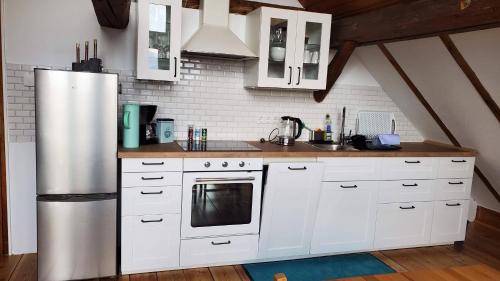 a kitchen with white cabinets and a refrigerator at Schulhaus Wettges in Birstein