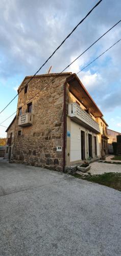 an old brick building with a white garage at Ecocasa Lema II in Muxia