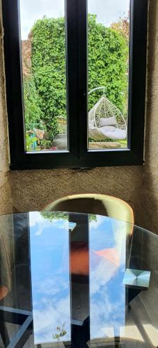 a glass table with a chair in front of a window at Ecocasa Lema II in Muxia