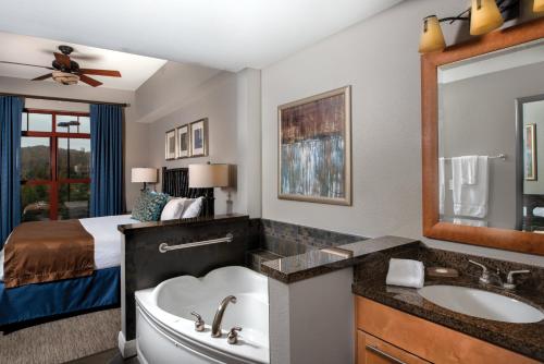 a bathroom with a tub, sink, mirror and bathtub at Club Wyndham Great Smokies Lodge in Sevierville
