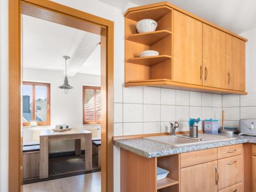 a kitchen with wooden cabinets and a sink at Stylish apartment with terrace in Sonneberg in Sonneberg