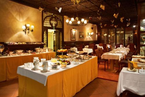 a dining room with tables with plates of food at Hotel Saturnia & International in Venice