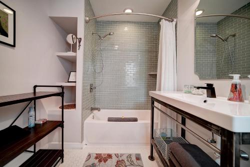 y baño con bañera, lavamanos y ducha. en Artsy Hidden Gem --- FREE PARKING, en Filadelfia