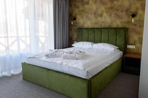 a bedroom with a large bed with white sheets and pillows at Venckai Venckuose in Venckai