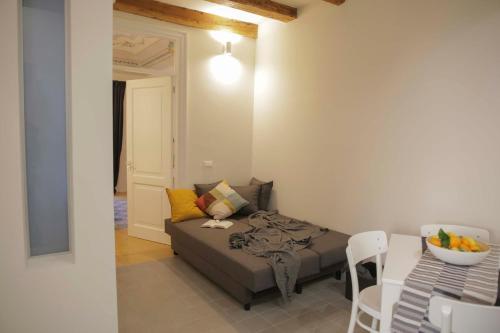 Habitación pequeña con cama, mesa y sillas en Turna Apartment en Cefalú