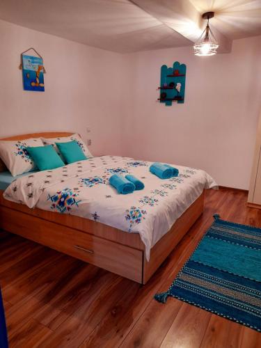 a bedroom with a bed with blue pillows on it at Casa Pavel Jurilovca in Jurilovca