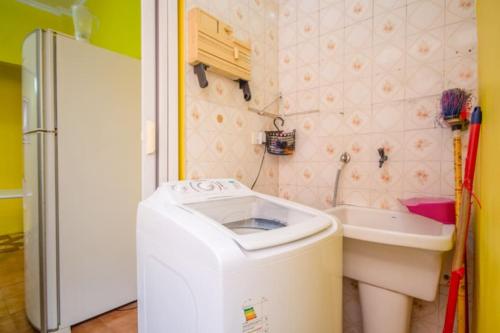 Il comprend une petite cuisine avec un évier et un lave-linge. dans l'établissement Apartamento Arouche, à São Paulo