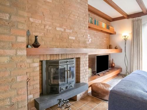 - un salon avec une cheminée en pierre et un canapé dans l'établissement Holiday home near the Efteling with garden, à Nieuwkuijk