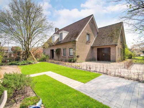a large brick house with a yard with a driveway at Holiday home near the Efteling with garden in Nieuwkuijk