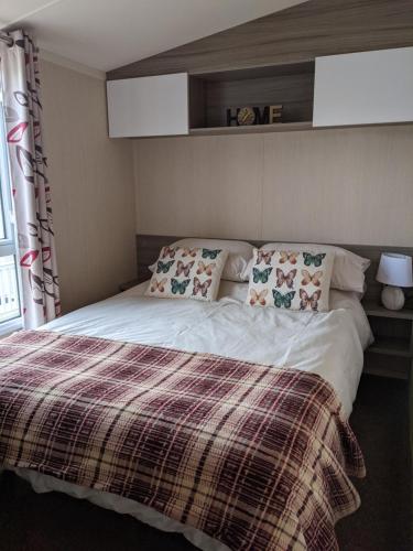 - une chambre avec un lit et une couverture tressée dans l'établissement 17 Sun Valley Holiday Park, à St Austell