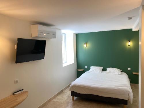 Jugeals-NazarethにあるLa Clef des Champsの緑の壁、ベッド付きのベッドルーム1室